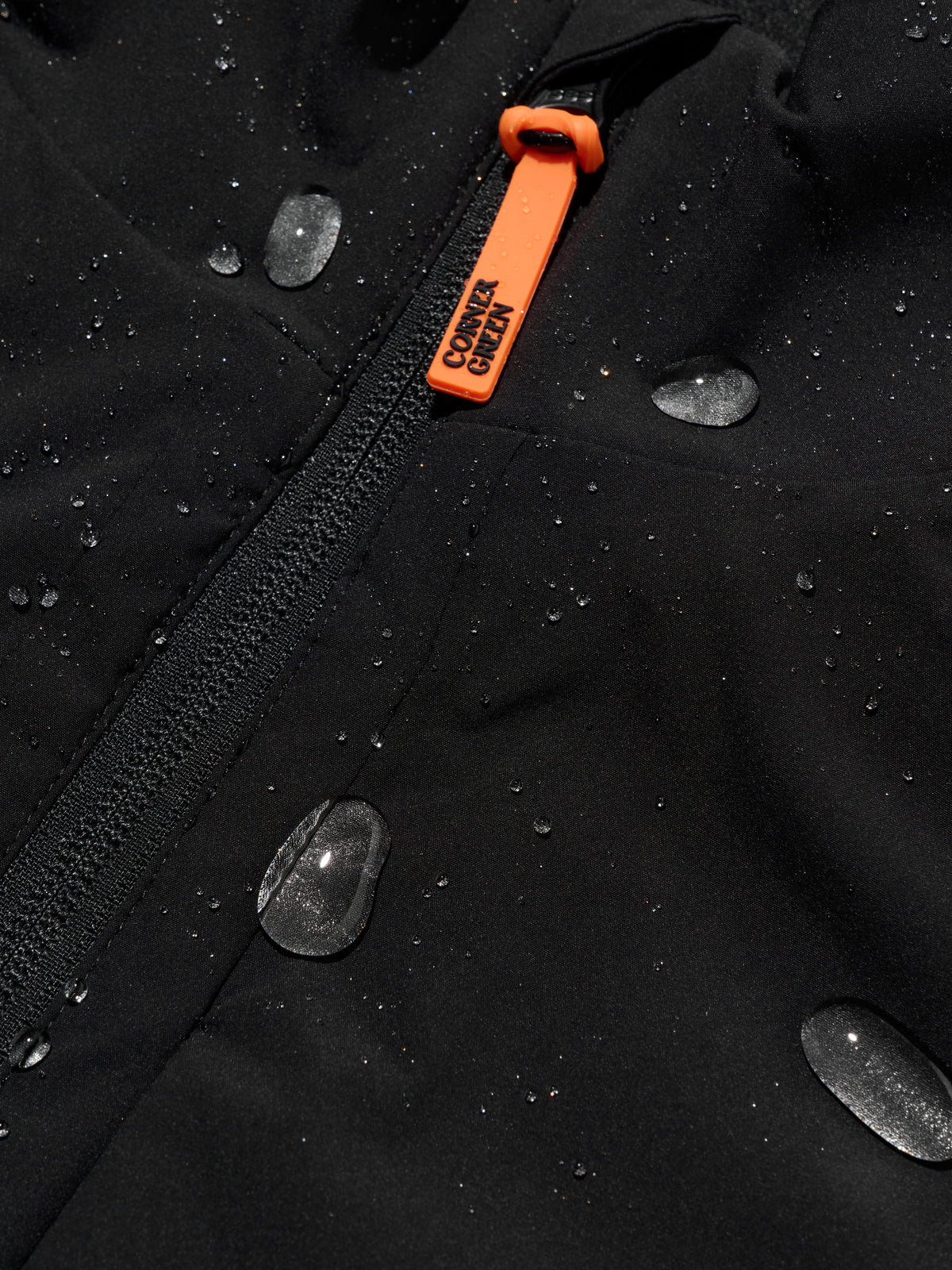 DRIVE Black golf wind jacket: water droplets beading on the crinkle-textured shell